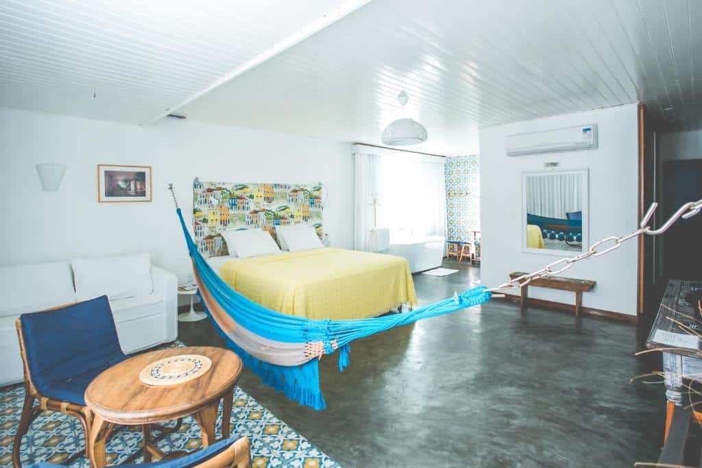 Quarto com cama de casal, rede, ar-condicionado e banheira na Pousada a Capela, uma das pousadas na Linha Verde na Bahia