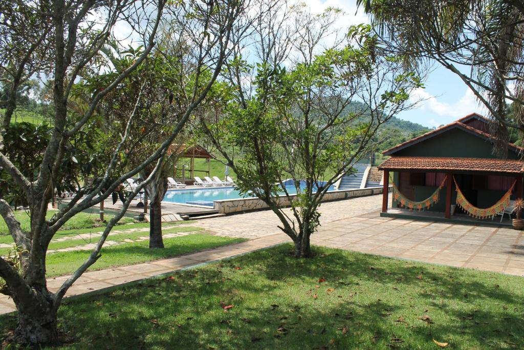 Área externa do Coronel Jacinto com jardim a frente, piscina ao fundo. Representa hotéis em Atibaia.