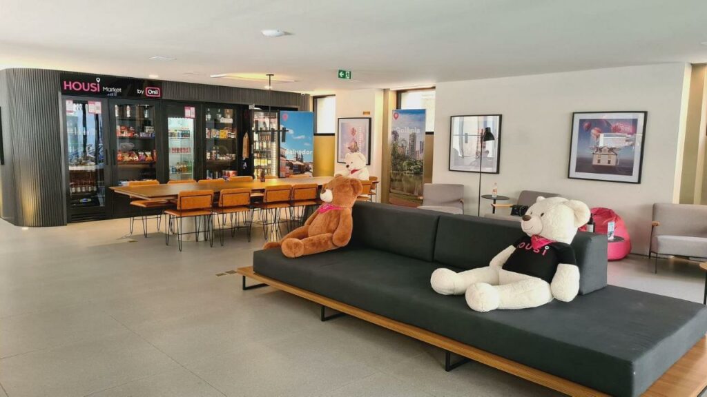 Sala do Housi Paulista com sofás, ursos e mesa