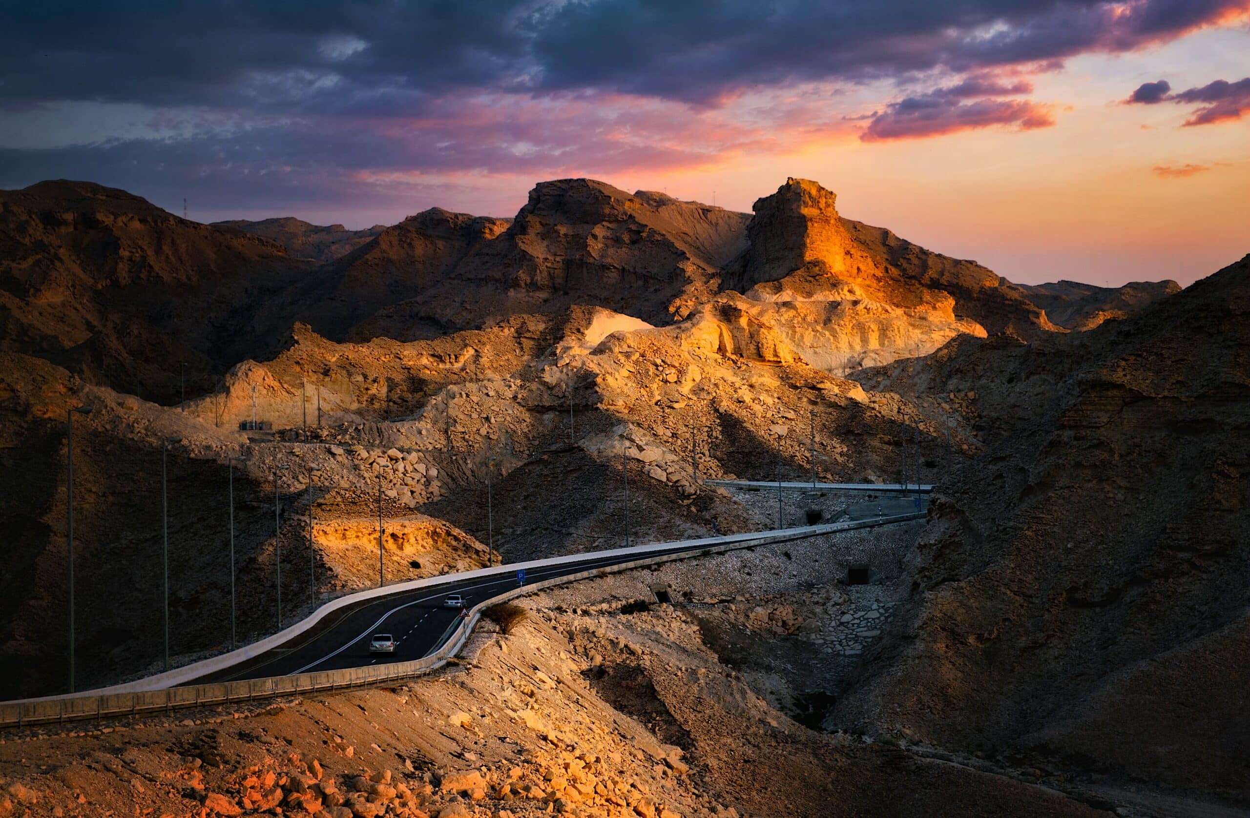 Montanhas rochosas Jebel Hafeet cortadas por uma estrada de asfalto