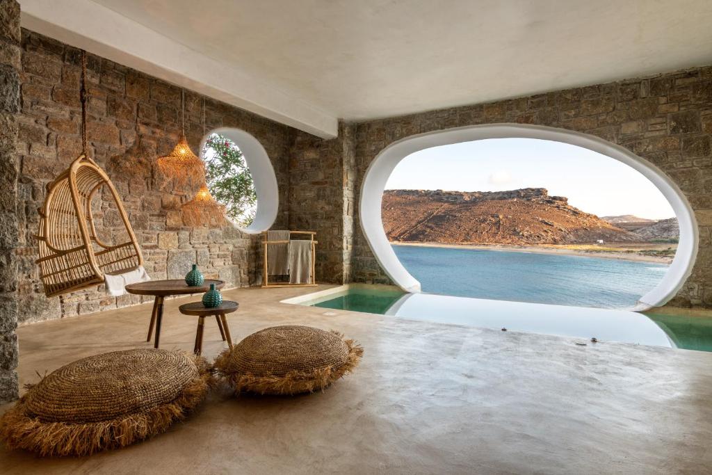 Quarto do Panormos Village, com piscina privativa e janela com vista para o mar de Mykonos