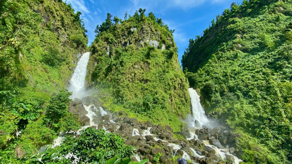 Vista da cachoeira Trafalgar Falls, Dominica, com queda d'água e vegetação em volta. - Representa seguro viagem Dominica.