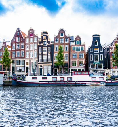 canal com barquinhos e casinhas coloridas em Amsterdã