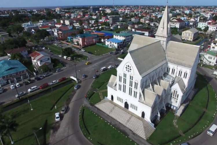 Vista de cima da região onde está localizada a Catedral de São George na capital de Georgestown na Guiana sob um céu azulado e sem nuvens.