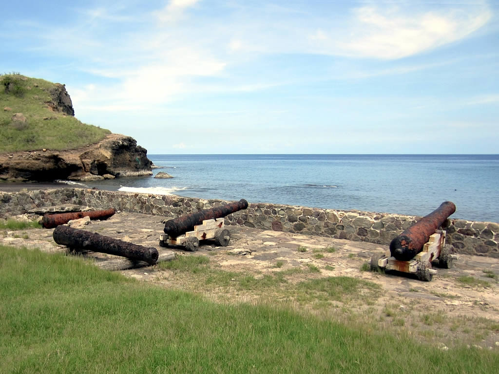 Alguns canhões muito antigos e enferrujados virados em direção do mar
