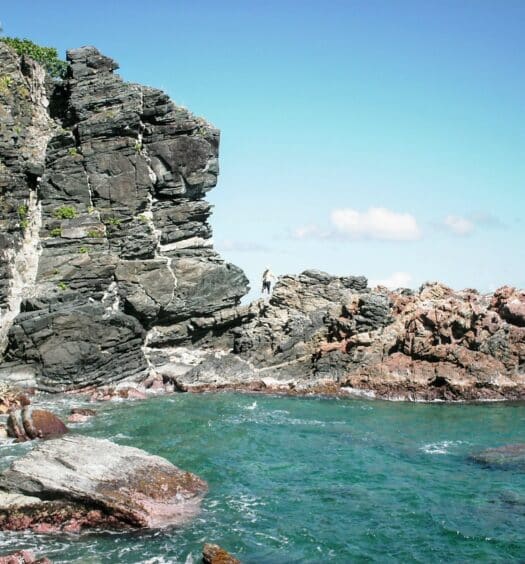 Muitas rochas formando um paredão contra a água transparente de Tortola em Ilhas Virgens Britânicas