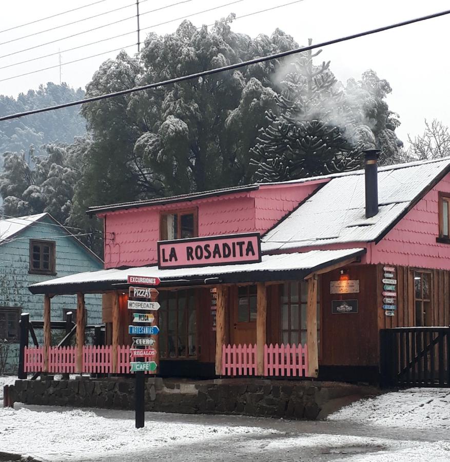 Fachada da cabana La Rosadita, toda pintada de rosa e com placa indicando o que oferece (excursões, pizzas, etc)