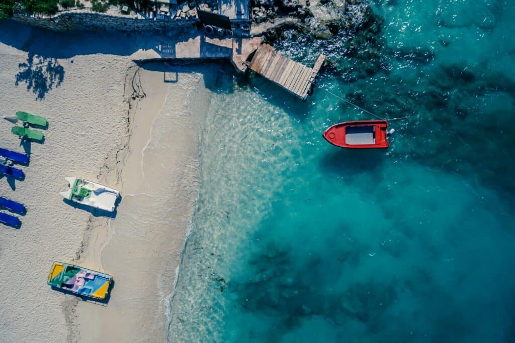vista aérea com barquinho da praia em Ksamil que pode ser visitada com o seguro viagem Albânia
