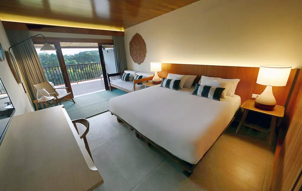 quarto deluxe do Club Med Trancoso com cama de casal, área de estar e uma varanda privativa