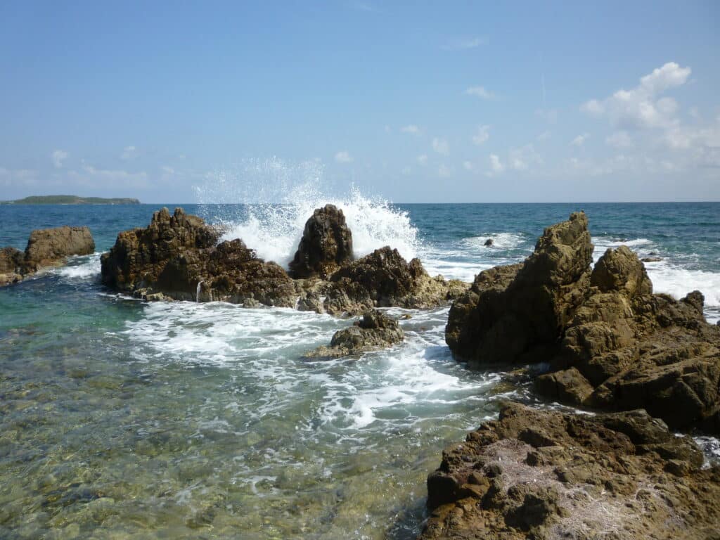 Rocky Beach em Vieques em Ilhas Virgens Espanholas, diversas formações rochosas encravados no mar, a água bate e forma uma espuma branca