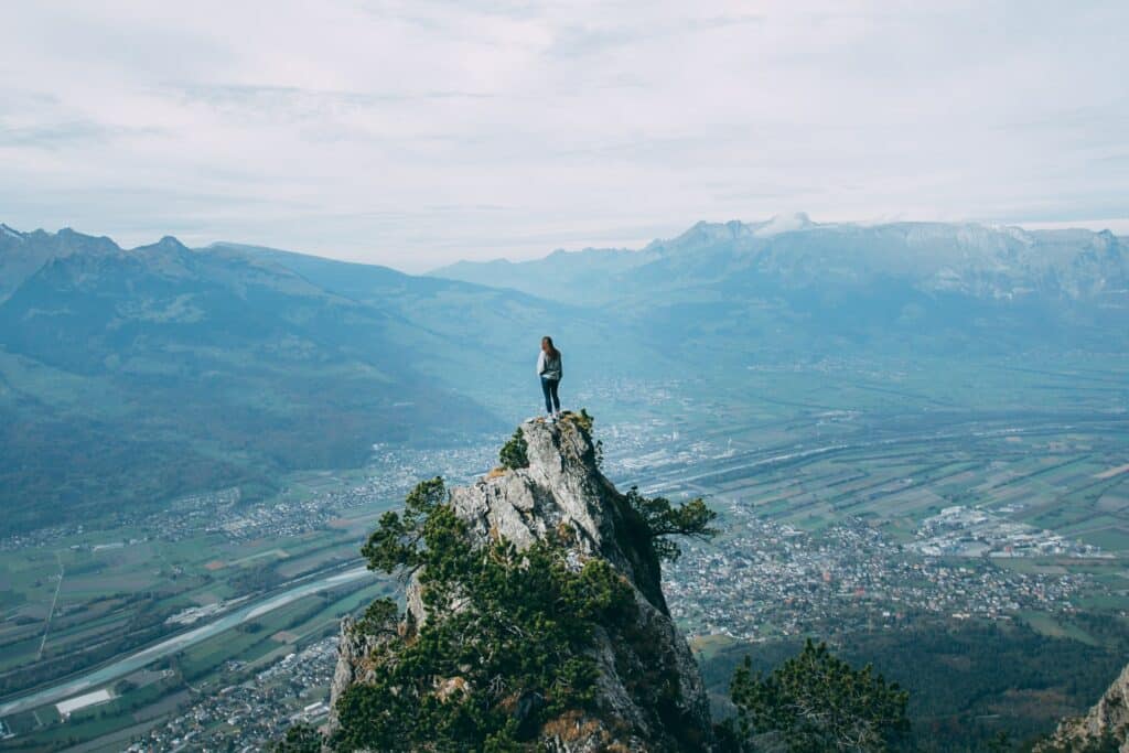 Menina no topo de uma rocha, em Silum, vila de Liechtenstein
