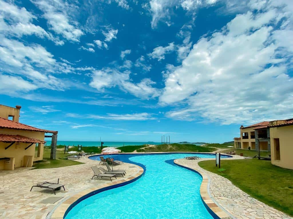 Piscina do Búzios Beach Resort, com vista para o mar e céu azul com nuvens espalhadas