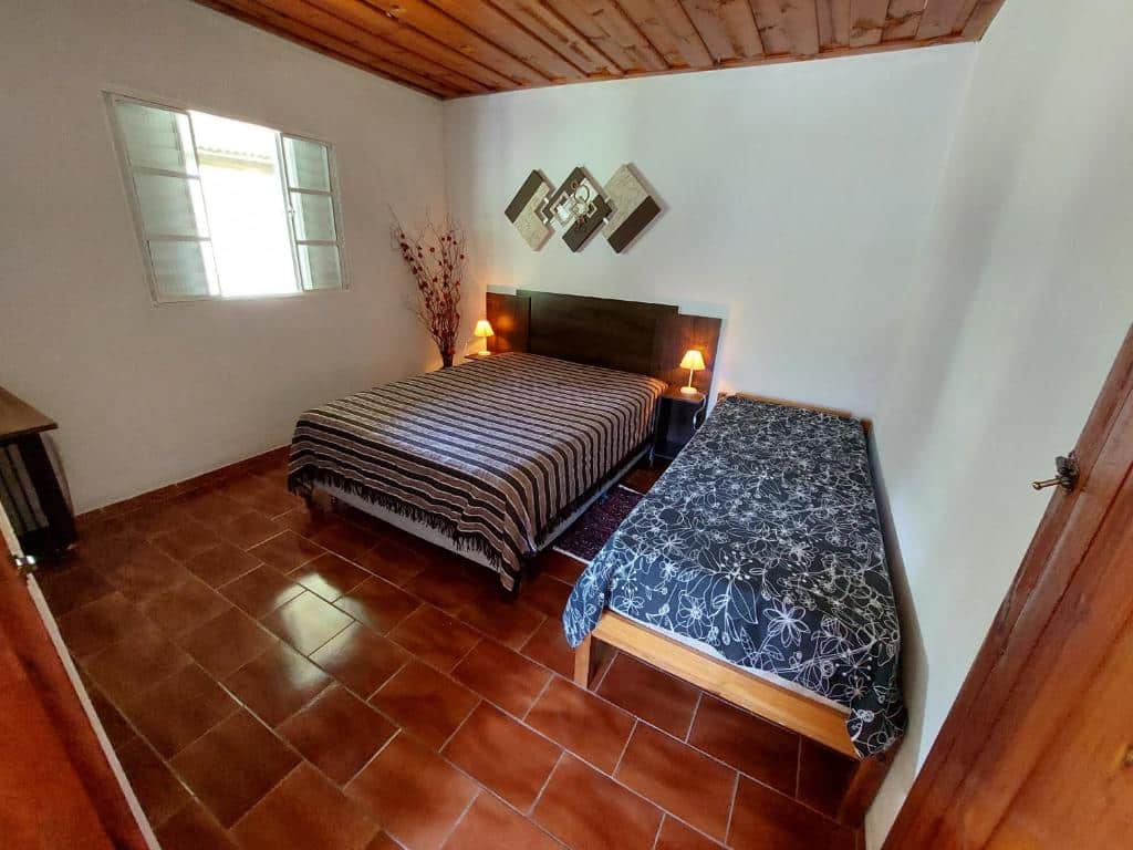 Quarto com duas camas de um dos airbnb em Gonçalves, a Casa aconchegante na roça