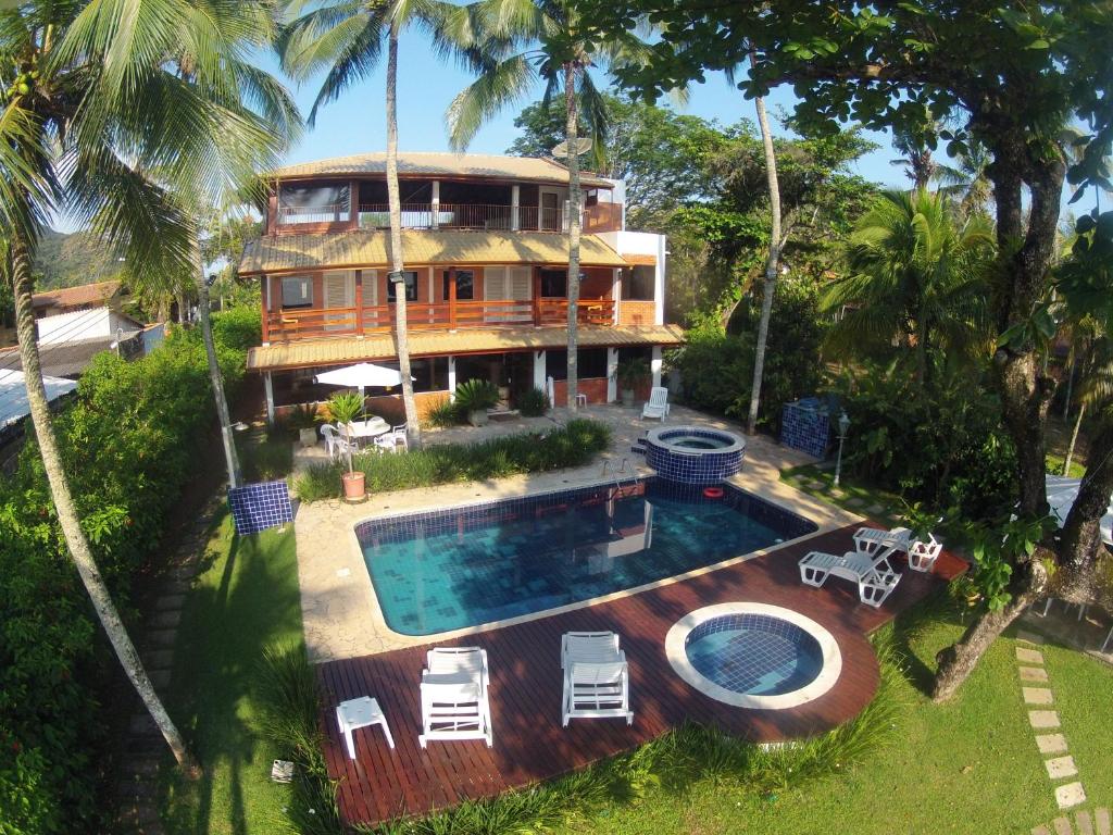 Vista aérea da Magnífica Casa na Praia do Lázaro Pé na Areia 4 suítes, com piscina, jardim, uma casa de três andares, cercada por árvores e arbustos, para representar airbnb na Praia do Lázaro