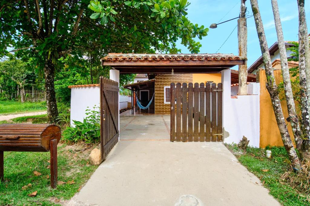 Entrada da Casa Ubatuba- praia da Lagoinha, portão de madeira, estrutura simples, uma rede na varanda, local cercado por vegetação