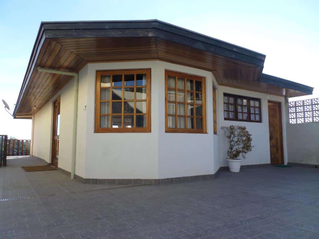 Entrada da Zanzarini House, construção nova, com janelas de madeira e pintada de branco
