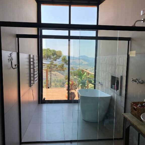 Chalé Oliva - Box de vidro do banheiro, com banheira e parede de vidro com vista para a montanha