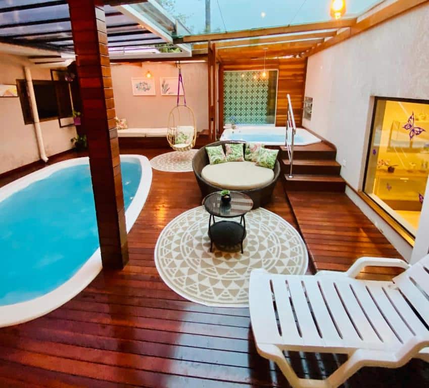 Área de lazer com piscina, hidro e poltronas de um dos airbnb em Curitiba