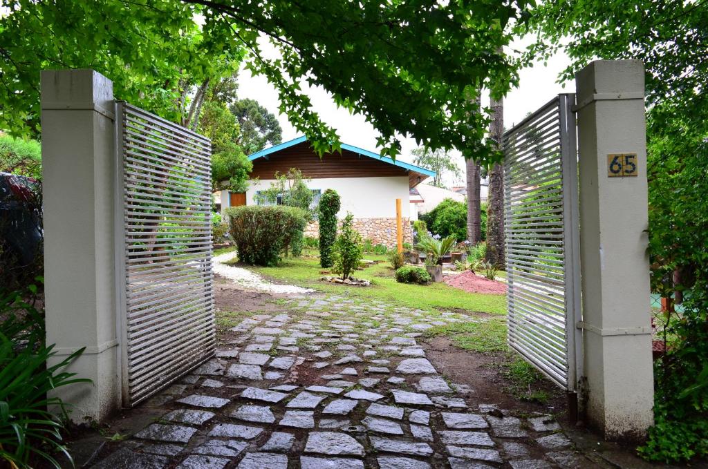 Entrada da Casa Sirin, um extenso jardim após o portão de entrada, muita natureza e a casa ao fundo
