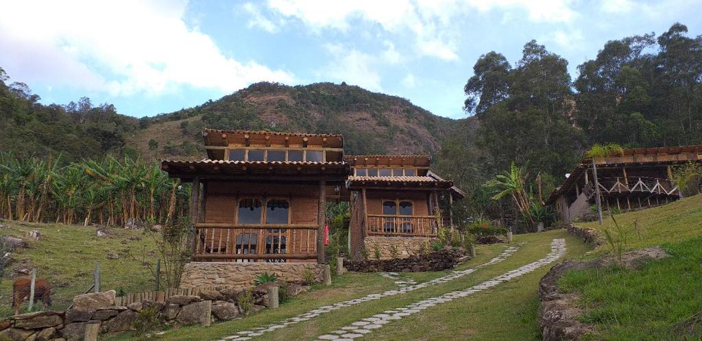 Vista do Chalé Refugio da Pedra feito de madeira e perto de montanha, em São Bento do Sapucaí.