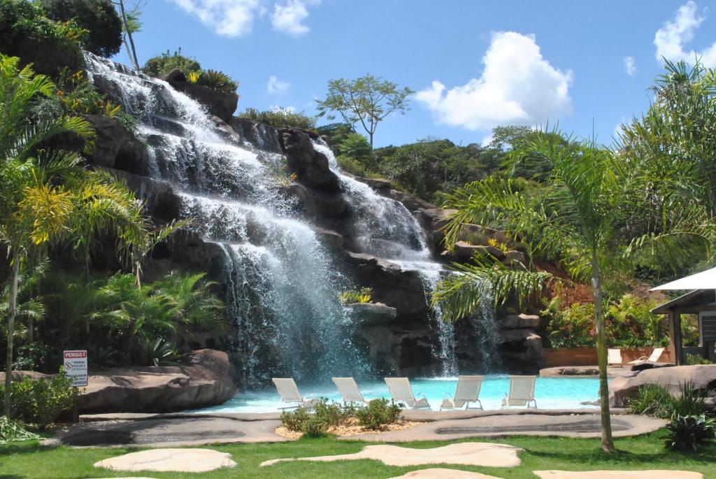 Cascata artificial no Hotel Fazenda Vista Alegre, com cinco degraus, formando uma piscina, com rochas e muita vegetação ao redor, além de espreguiçadeiras