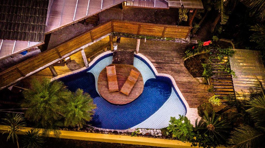 Vista da piscina e o deck da  Itamambuca Casa das ondas, local amplo, rústico e com árvores