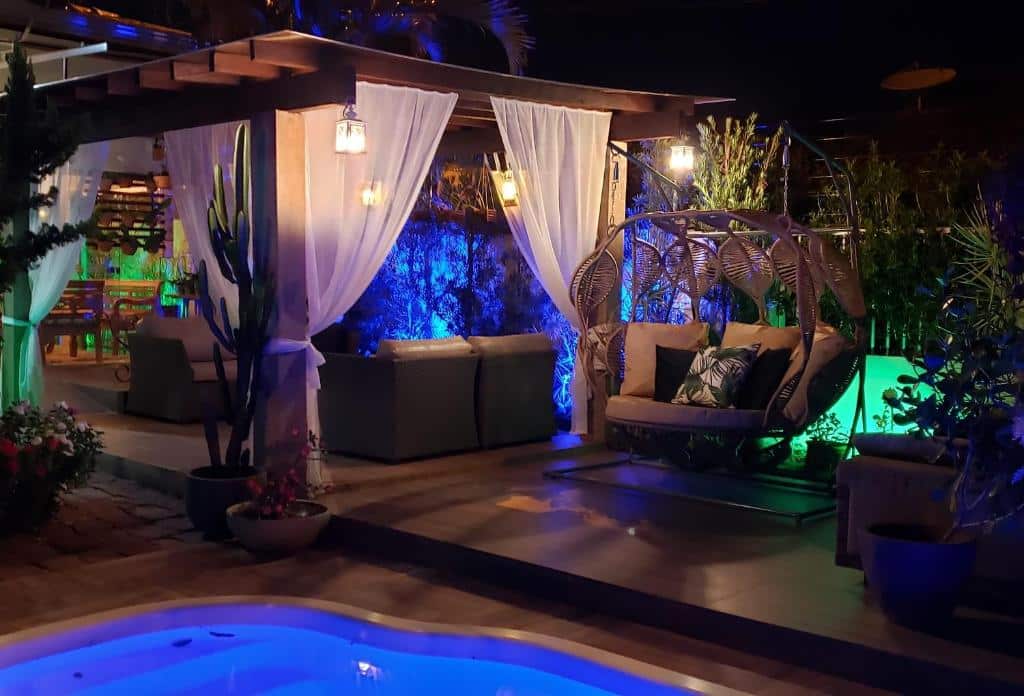 piscina da Pousada das Orquídeas com uma varanda mobiliada à noite