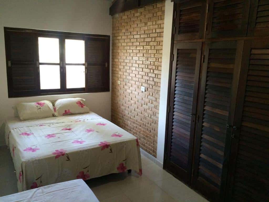 Quarto em Ampla casa com piscina a 200 metros da praia do Lazaro e Sununga, uma cama de casal, uma janela e um armário, para representar airbnb na Praia do Lázaro