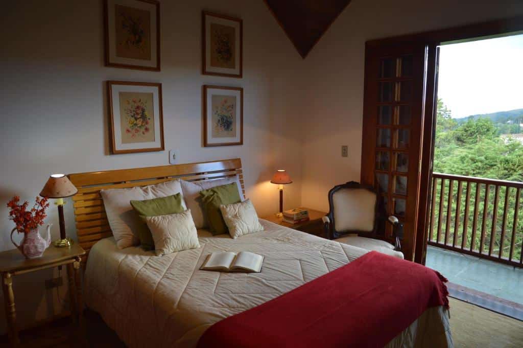 Quarto no Apartamento Espaçoso Vista Montanha, uma cama de casal, uma decoração vintage, uma poltrona, uma sacada ampla, dois abajures, para representar airbnb em Campos do Jordão