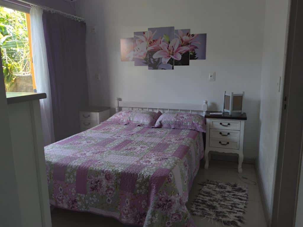 Vista do quarto Casa Completa no Rosa com cama ampla e cômodas, na Praia do Rosa.
