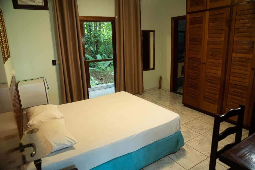 Quarto Casa Bela Vista Ubatuba - Tenório com cama ampla, armário e frigobar.