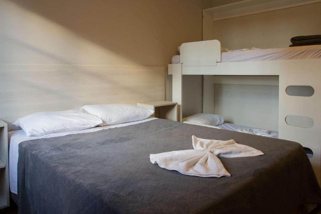 Quarto em Incrível apartamento no Centro de Gramado , uma cama de casal e uma beliche, para representar airbnb em Gramado