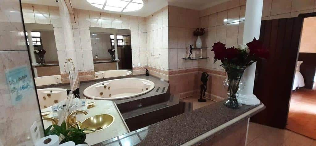 banheiro da Pousada Villa Guimaraes com uma bela banheira de hidromassagem