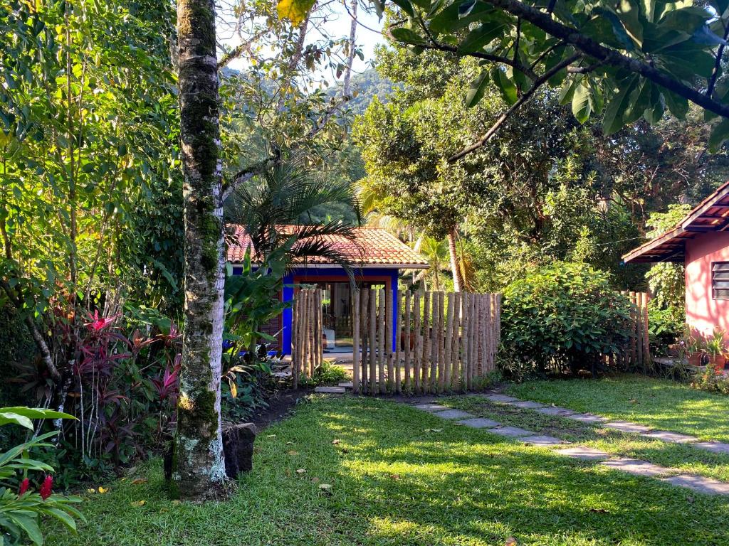 Quintal em Vila dos Tangarás, uma entrada com muita grama, um portão de madeira, árvores e muita vegetação ao redor