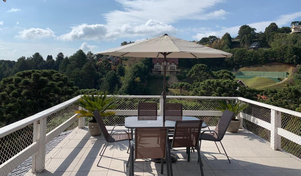 Sacada da Casa centro Capivari 700m distância, com uma mesa de seis lugares com um guarda-sol e vista para as montanhas