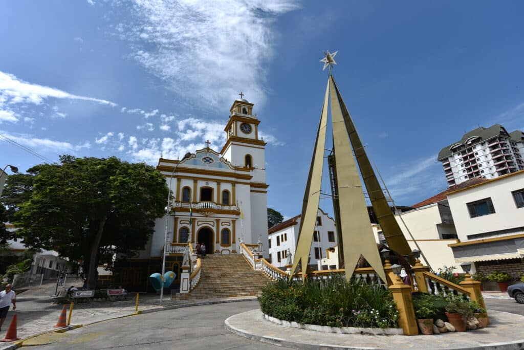 Basílica Menor de São Lourenço Mártir em São Lourenço, uma igreja com uma monumento logo na frente em formato de uma árvore, local com construções históricas e antigas