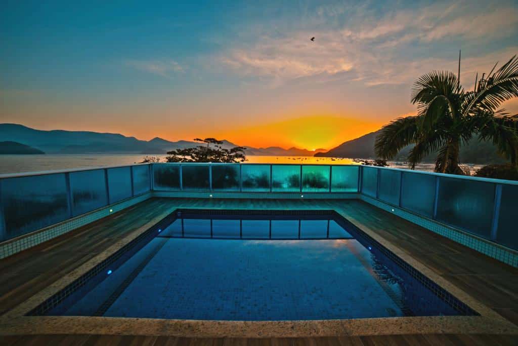 Vista da piscina do  Ubatuba Praia Hotel, em direção da praia, montanhas e pôr-do-sol