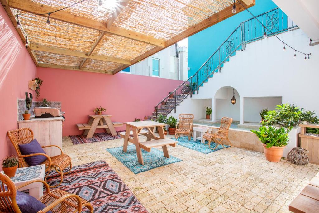 varanda do BOHO Bohemian Boutique Hotel em Curaçao com mesas para café da manhã e uma pequena piscina ao pé da escada no canto direito da imagem