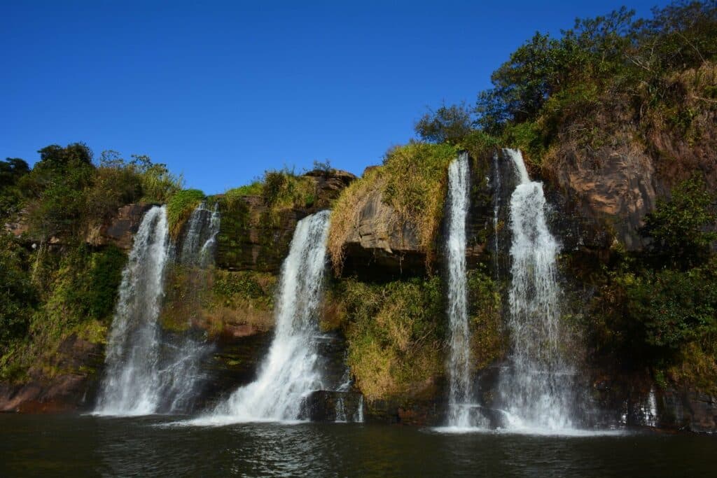 Cachoeira da Fumaça em Carrancas, três quedas d'água cercada por rochas e vegetação