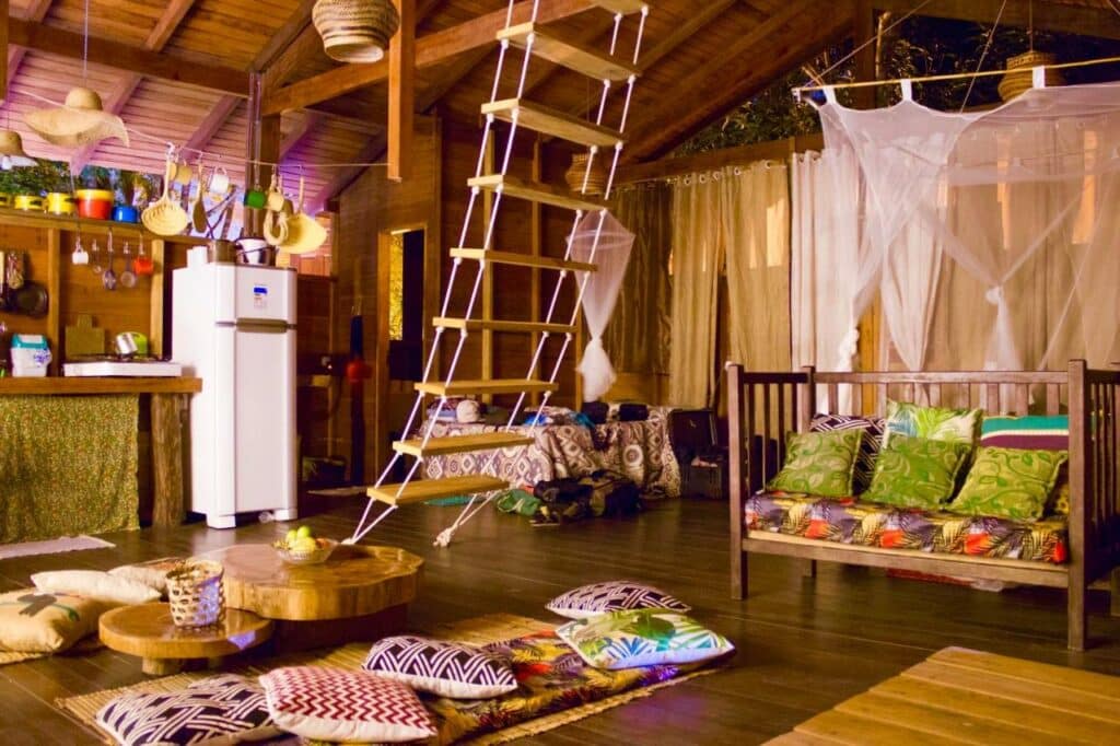 Sala de estar e quarto da CASA DA ARVORE, sonho na Amazônia, 50m da praia, com muitos elementos lúdicos de uma casa na árvore, almofadas, tudo em madeira e rústico, para representar pousadas em Alter do Chão