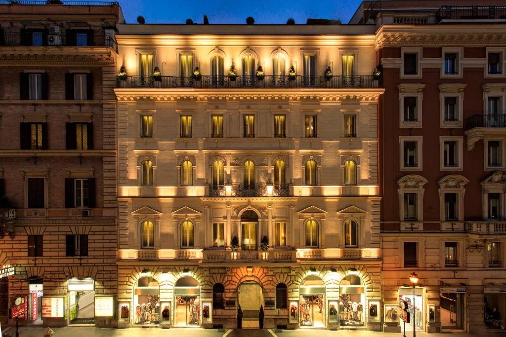 fachada do Hotel Artemide com várias janelinhas e luzes à noite com cores claras