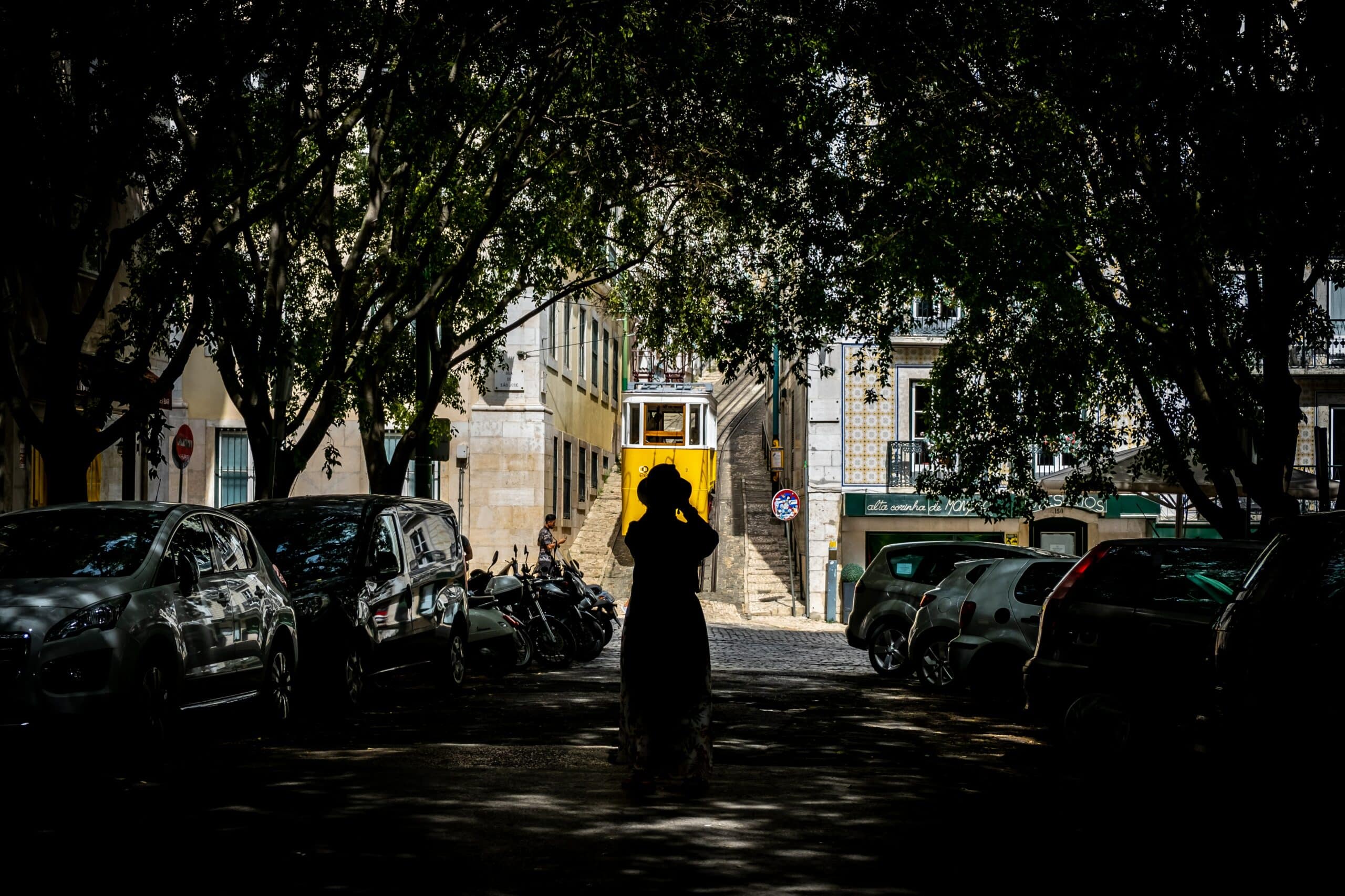 mulher tirando foto do bonde amarelo em lisboa, portugal