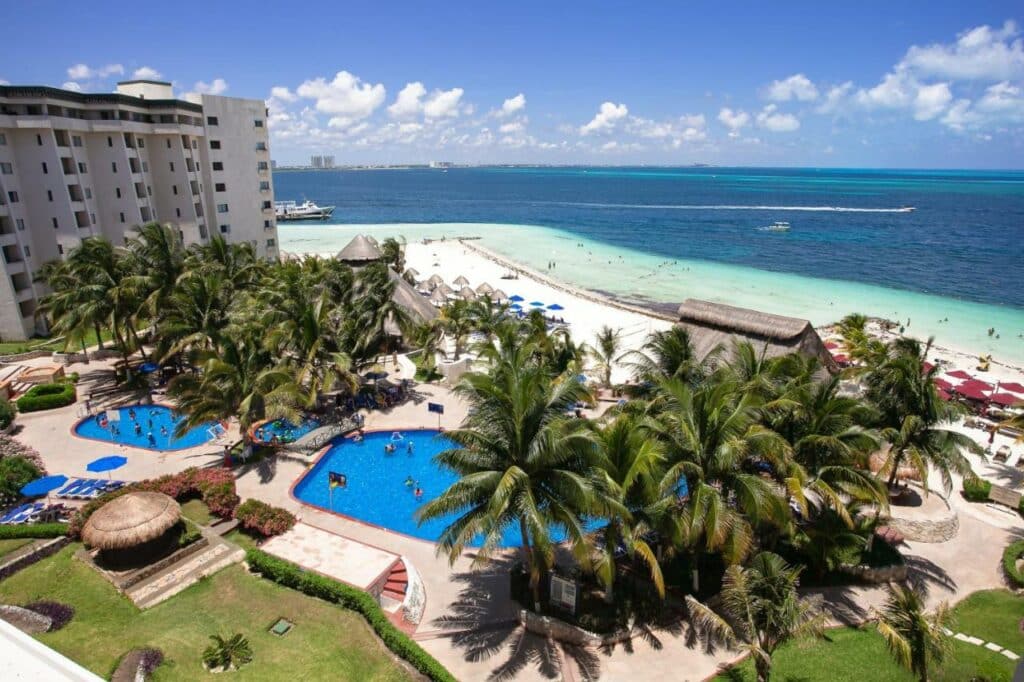 Vista aérea do Hotel Casa Maya com piscina, cercado de árvores e com vista para o mar, a praia fica logo em seguida do hotel