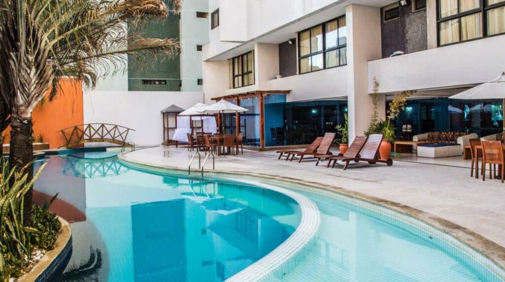 Piscina do Hotel Village Premium Joao Pessoa com um deck composto por espreguiçadeiras