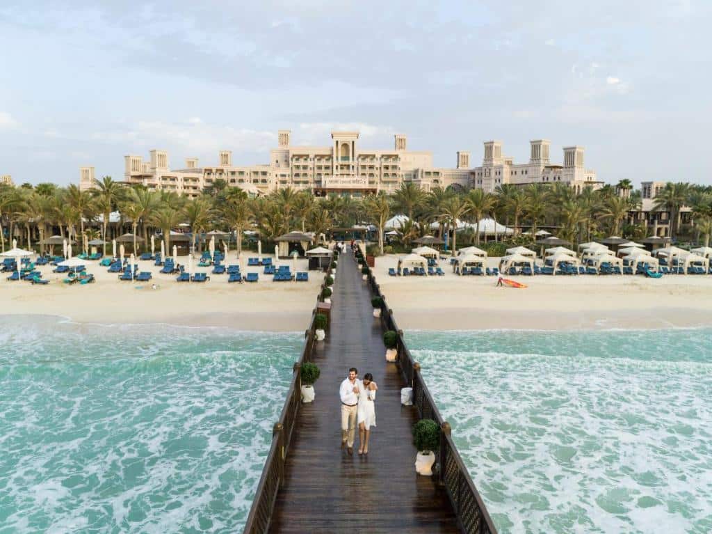 Casal caminhando em passarela, em cima do mar, do Jumeirah Al Qasr, um dos hotéis em Dubai