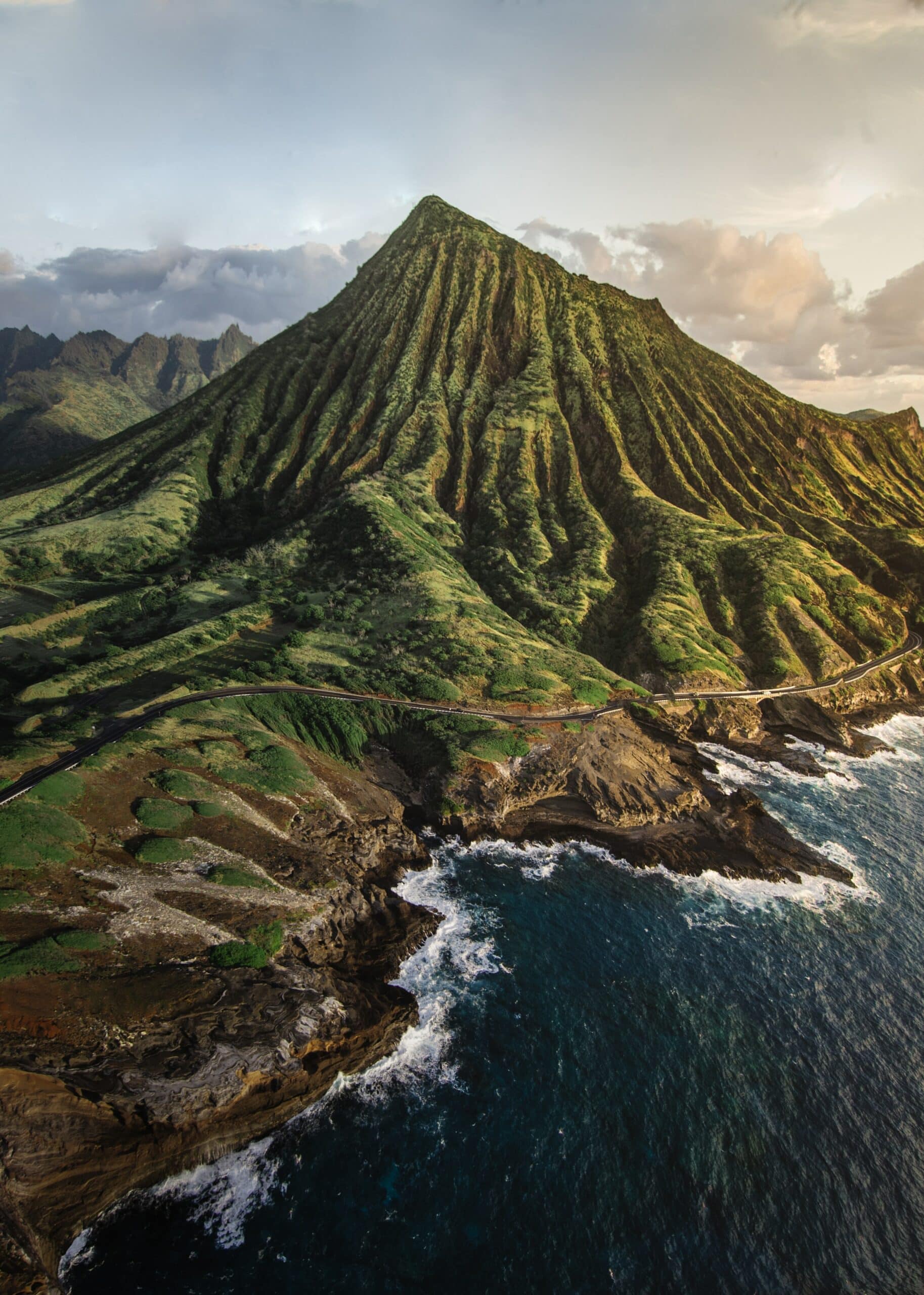 Montanha com estrada e mar bravo com rochas, em Oahu, Havaí, para representar o seguro viagem Havaí.