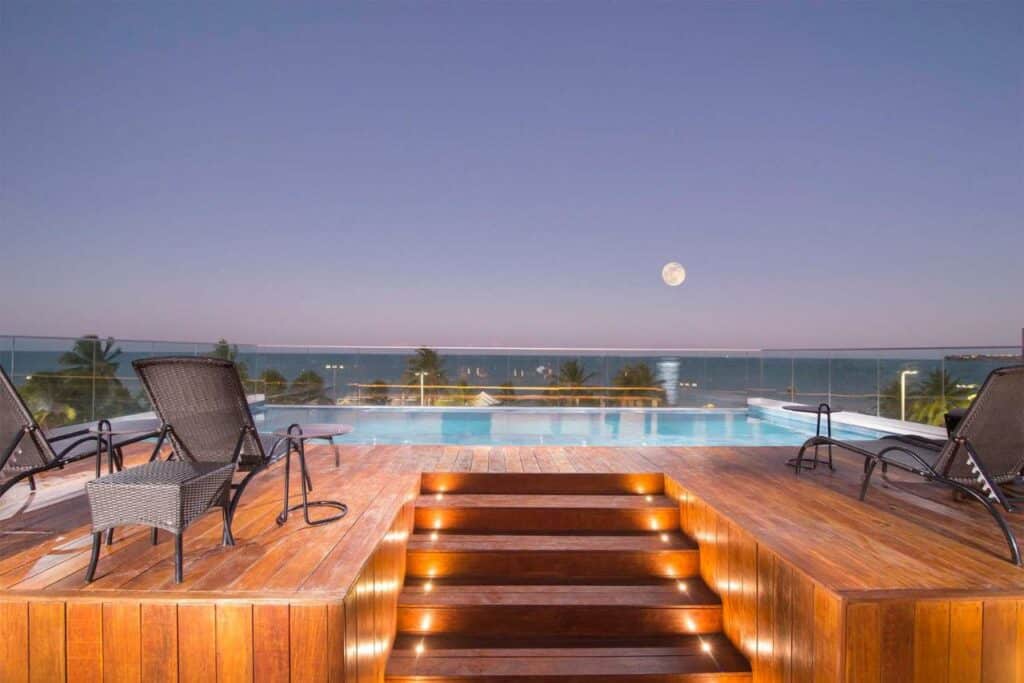 Piscina no Infinity at the Sea by Welkom com vista para o mar e a praia, com um deck cercado em vidro