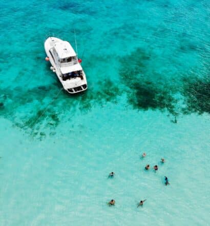 playa el cielo em cozumel com pessoas e barco em águas cristalinas ilustrando post seguro viagem cozumel