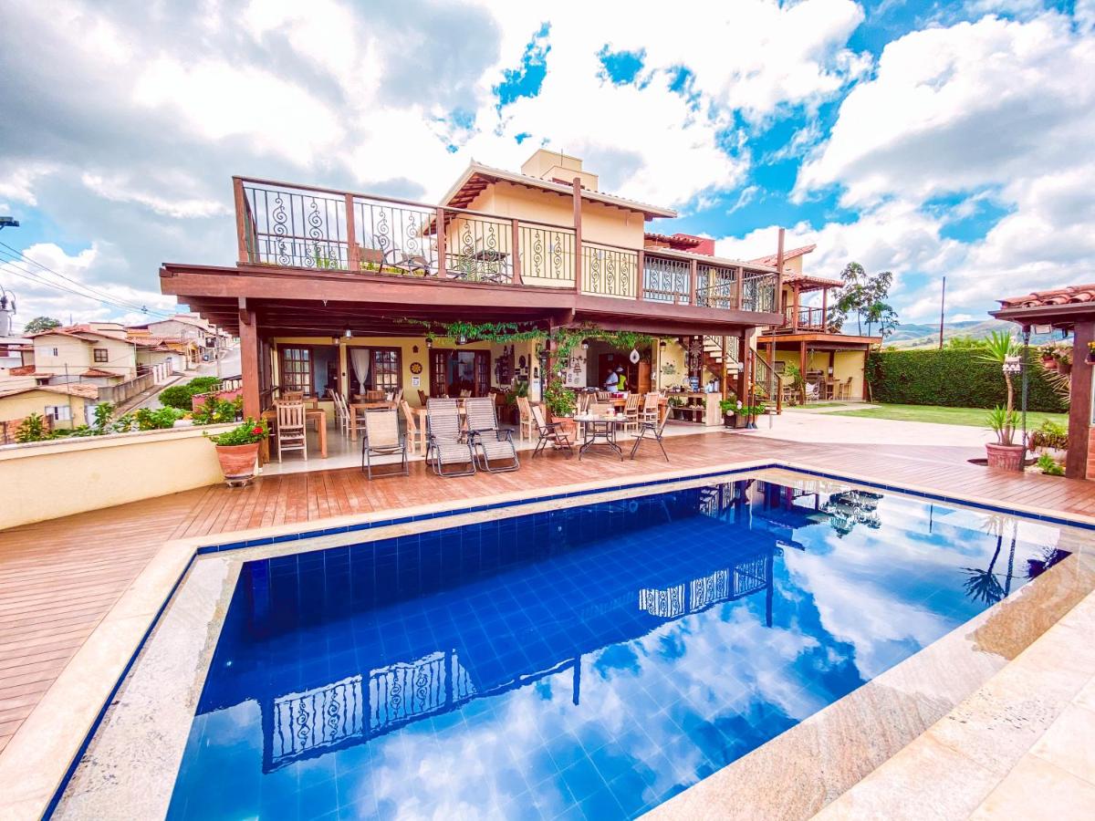 Uma piscina da Pousada Quintal da Lua com uma casa e um deck.