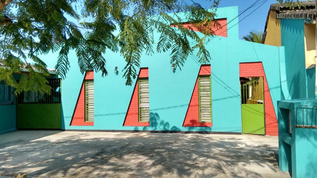 Área da Pousada Recanto Renascer, uma das pousadas em Caraguatatuba, com janelas de vidro e porta de metal